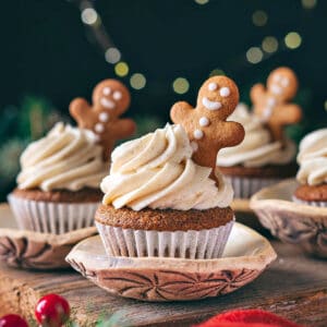 Wooden surface with frosted gingerbread cookies. Dark background. Cookie decorations.