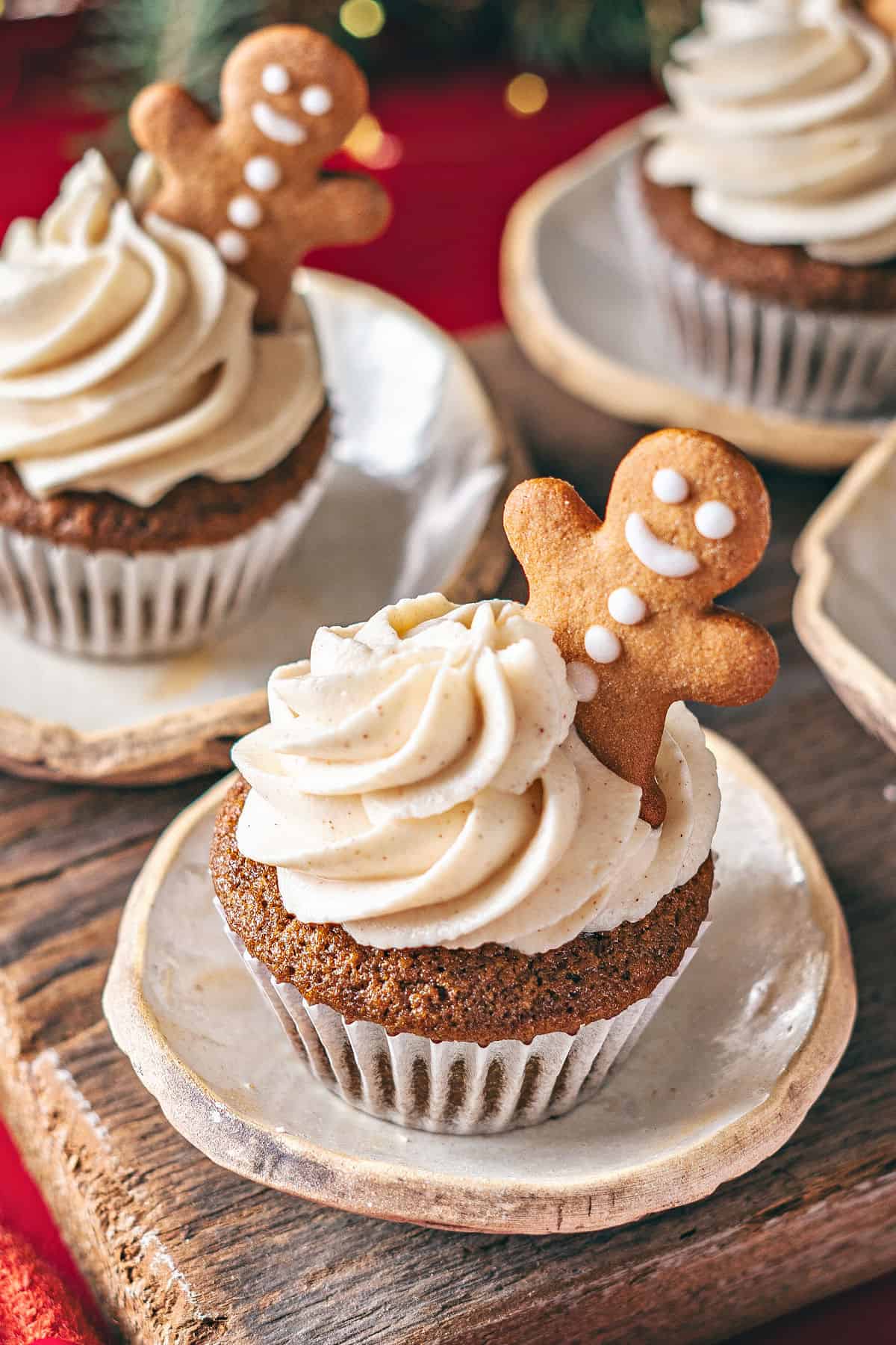 Spice frosted gingerbread cupcakes on white plates. Ginger cookie decoration.