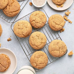 Several crackly snickerdoodles on wire racks. Light gray surface.