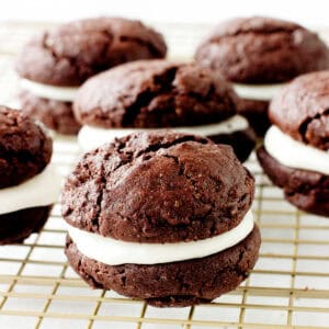 Creme-filled chocolate whoopie pies on a gold wire rack.