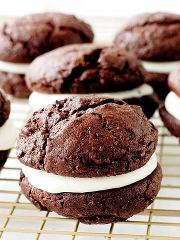 Creme-filled chocolate whoopie pies on a gold wire rack.