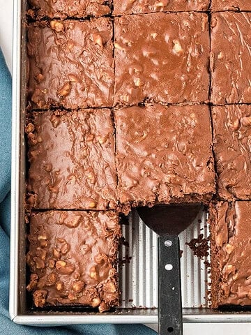 Metal pan with chocolate walnut sheet cake. Spatula, square missing.