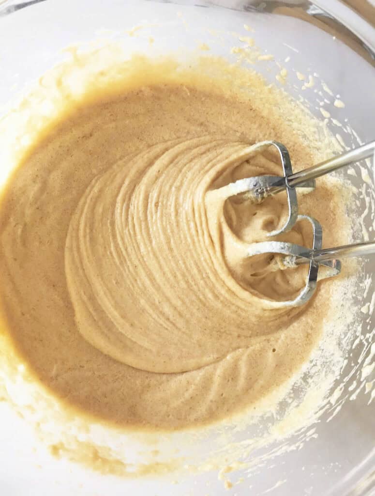 Glass bowl with pound cake batter and metal beaters.