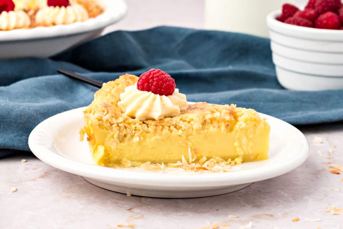 White plate with slice of impossible coconut pie. Blue background.