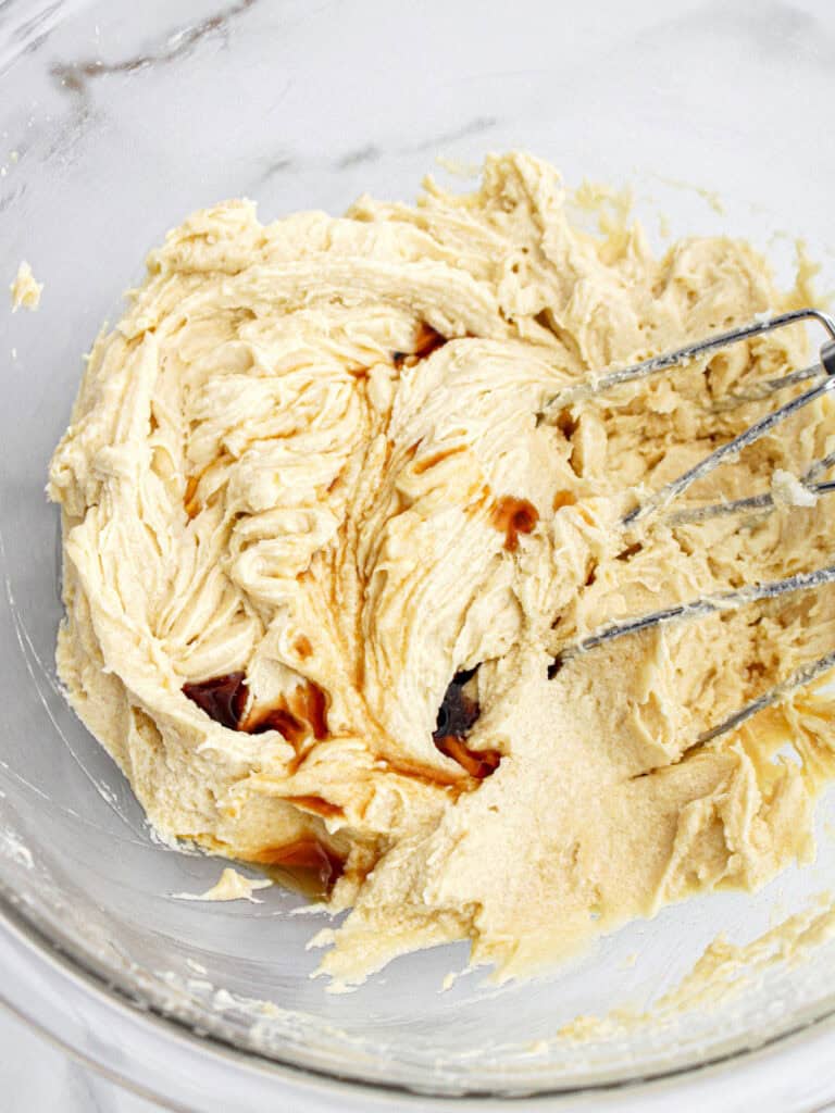 Cake batter with vanilla in a glass bowl. Marbled background.