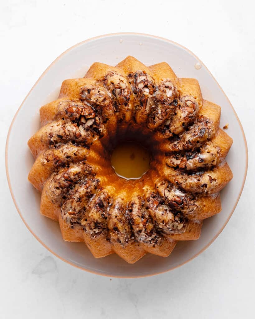 Soaked pecan rum cake on a white plate. Top view.