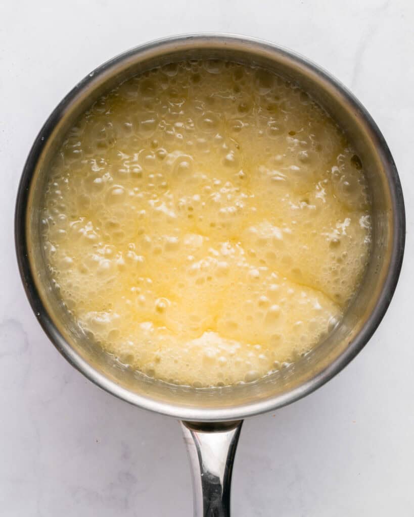 Metal saucepan with bubbling rum syrup.