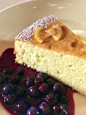 Orange cake slice with blueberry sauce. 