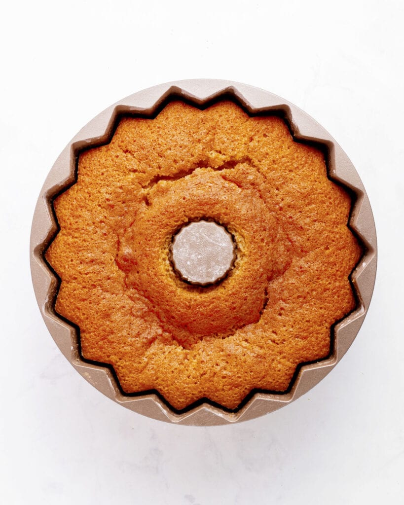 Baked rum cake in a bundt pan. White background.
