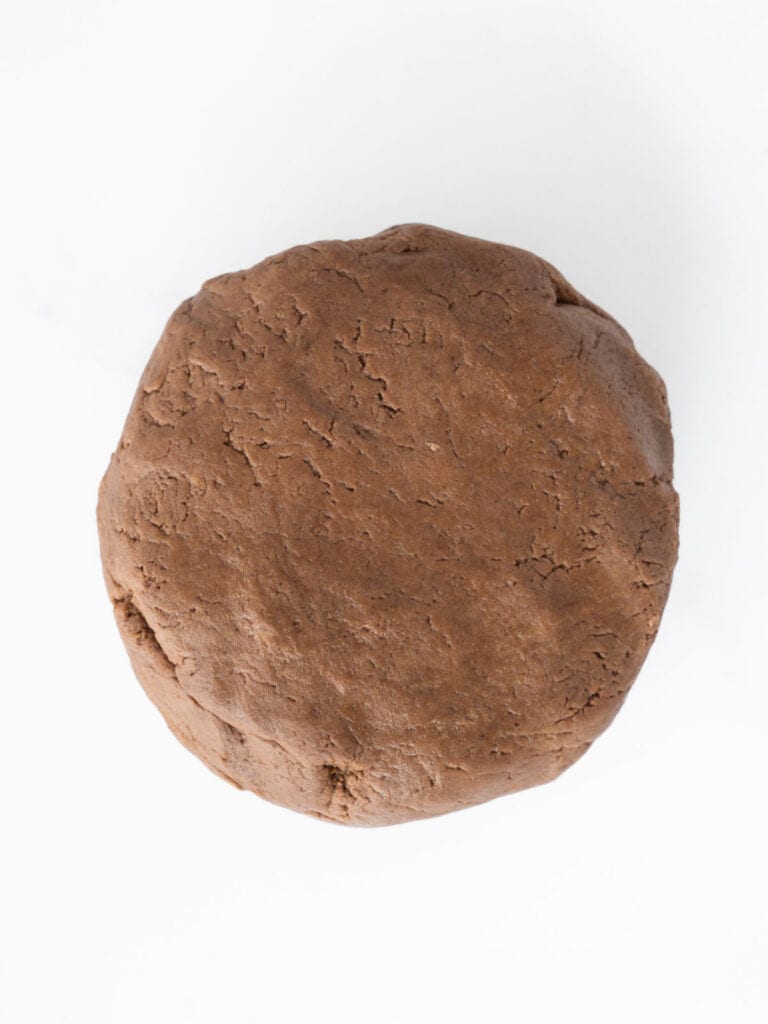 White background with round of chocolate dough.