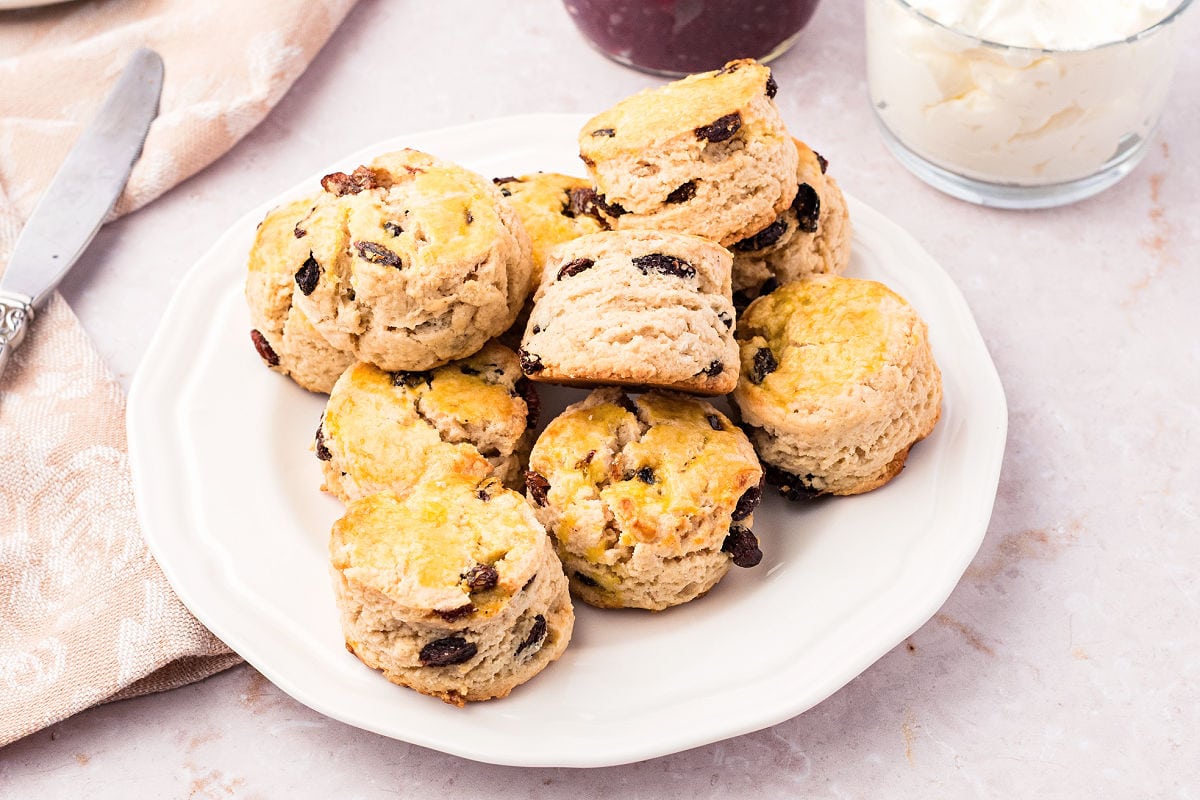 White plate of raisin scones. Light gray background.