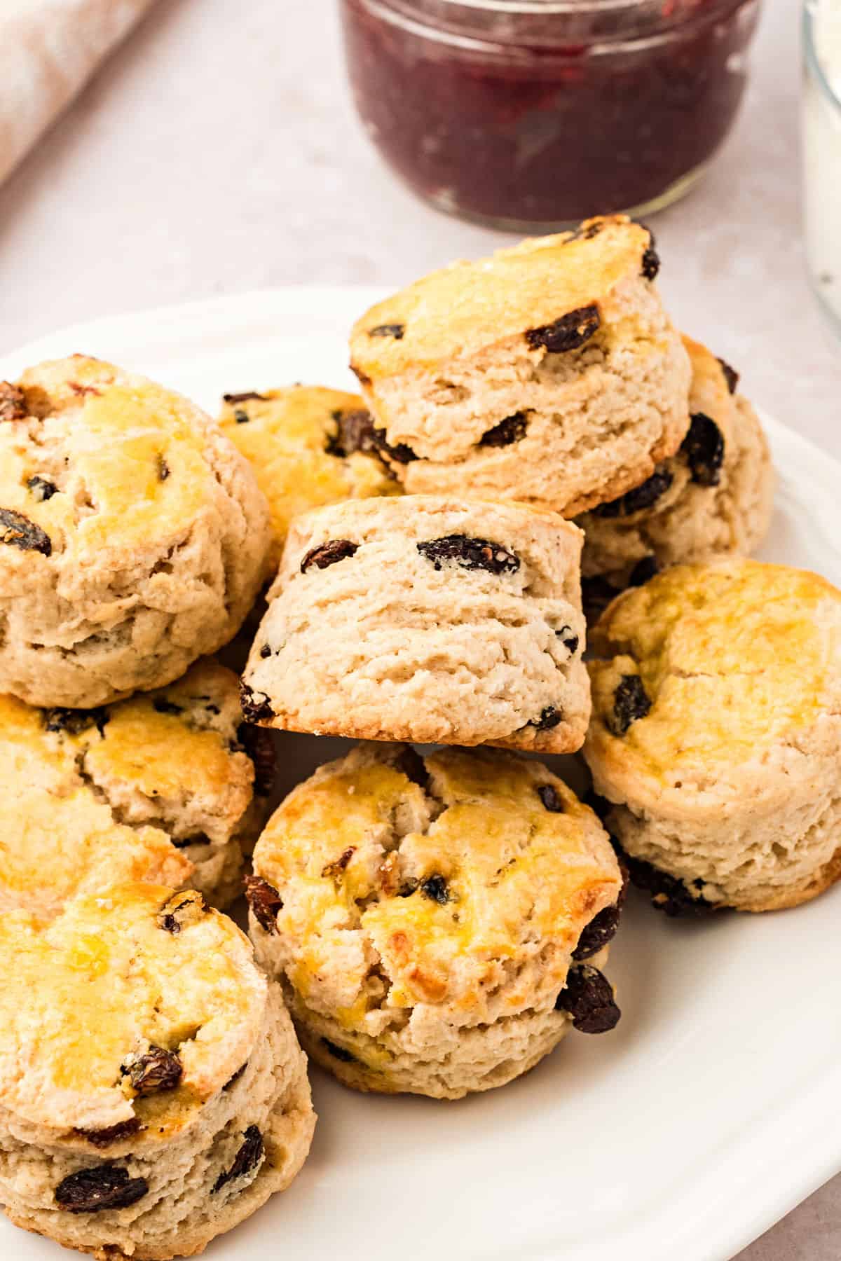 Pile of English raisin scones on a white plate.