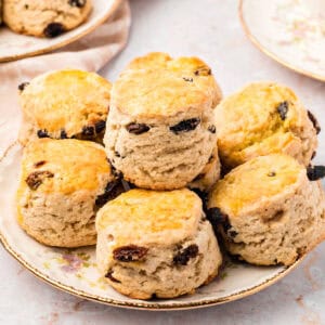 Raisin scones on a vintage plate. Cream colored background.