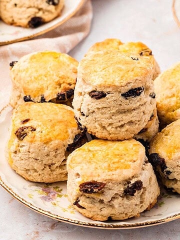 Raisin scones on a vintage plate. Cream colored background.