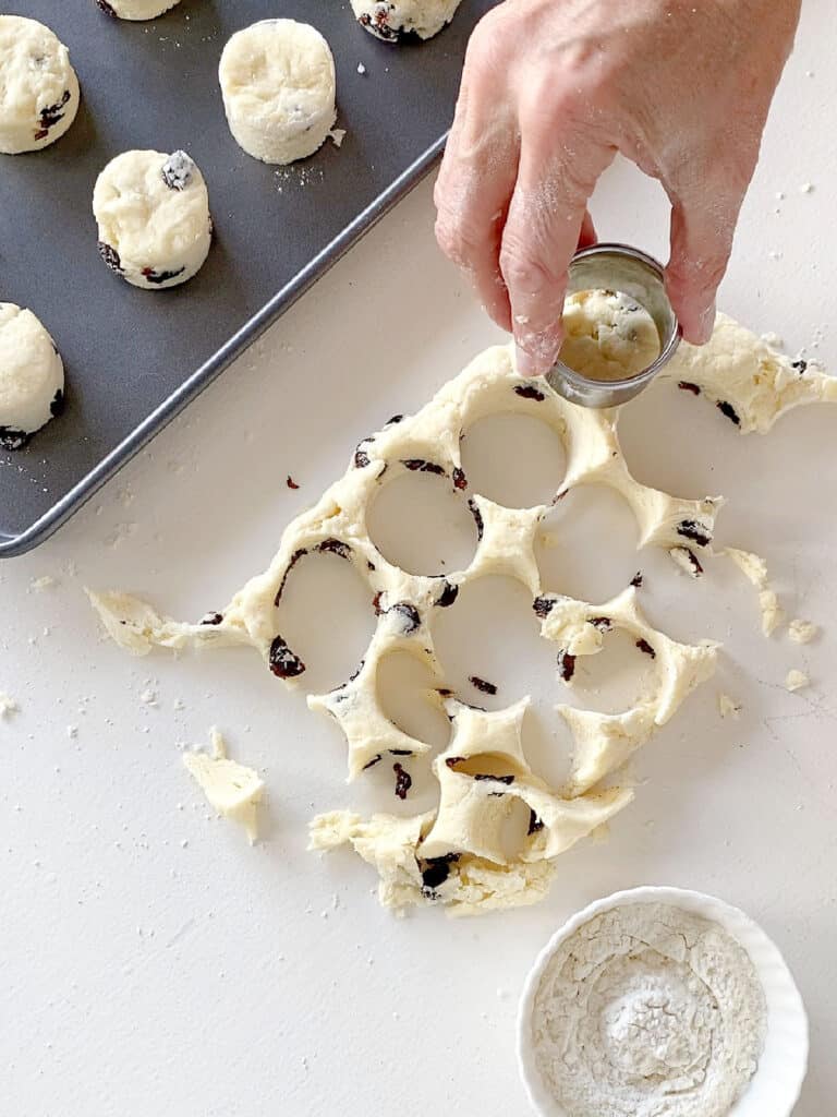 Cutting raisin scones on a white surface.