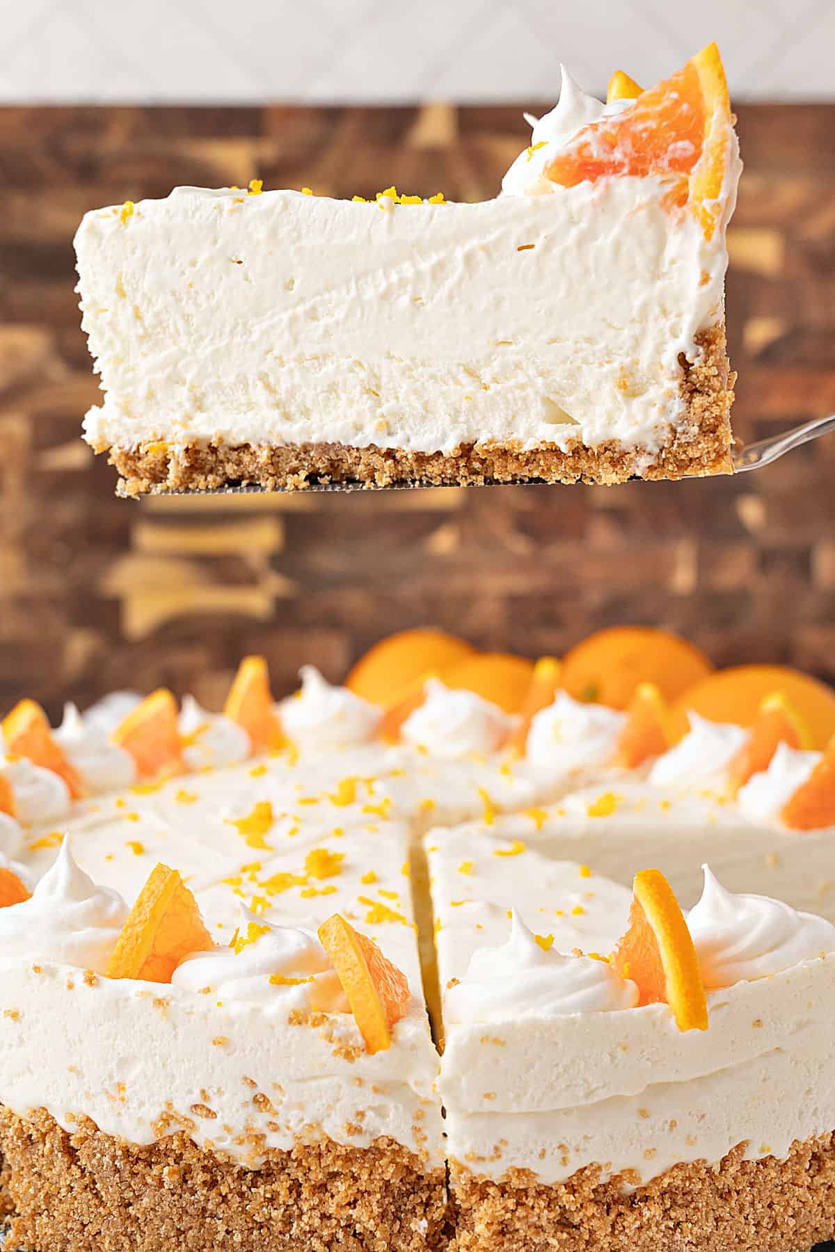 Brown background with slice and whole orange cheesecake.