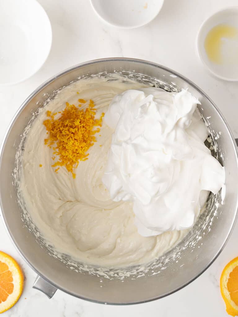 Metal bowl with cheesecake mixture, cool whip and orange zest.