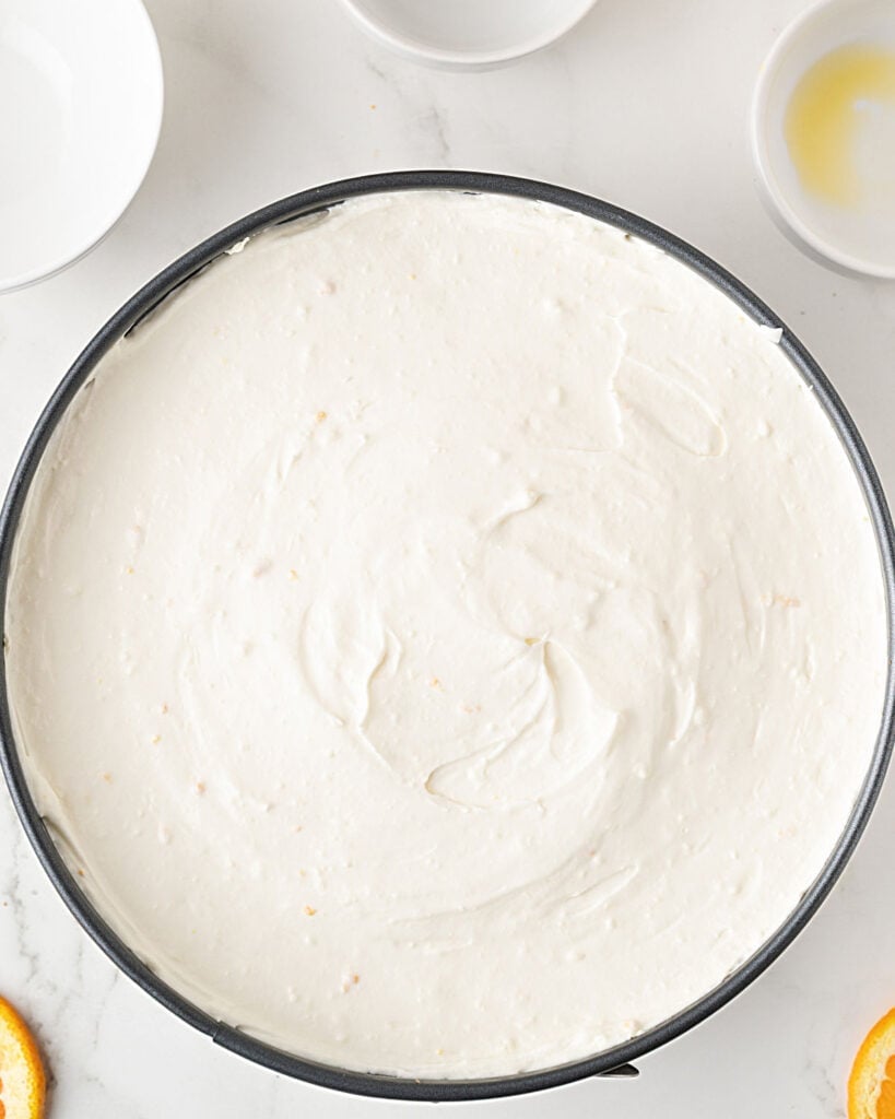 Round cake pan with no bake orange cheesecake filling.