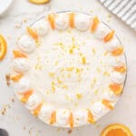 Decorated whole orange cheesecake. White background. Top view.
