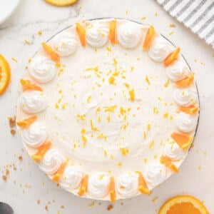 Decorated whole orange cheesecake. White background. Top view.