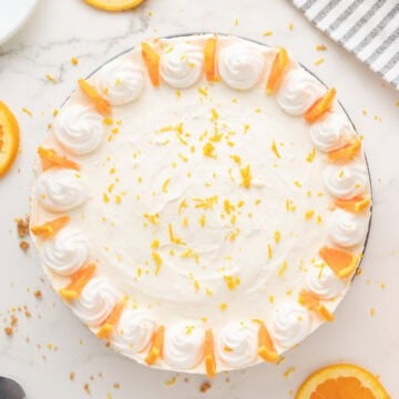 Decorated whole orange cheesecake. White background. Top view.
