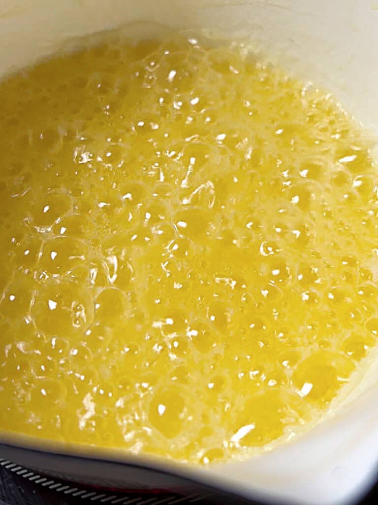 Bubbling butter in a white saucepan.