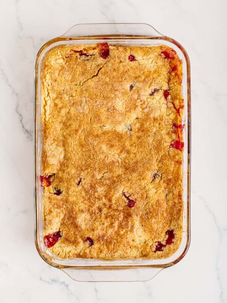 Baked dump cake in a rectangular glass baking dish. White marble background.