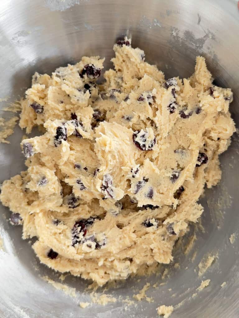Metal bowl with cookie dough with chips and raisins. Top view.
