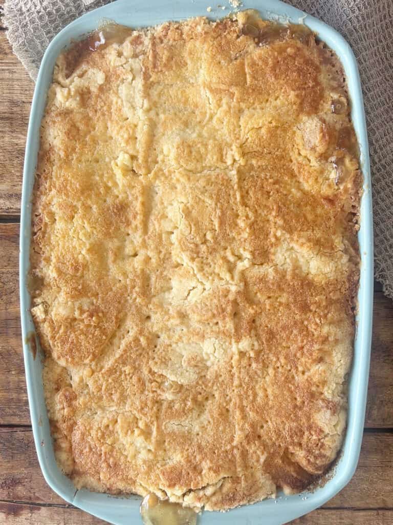 Baked classic apple dump cake in a blue baking dish.