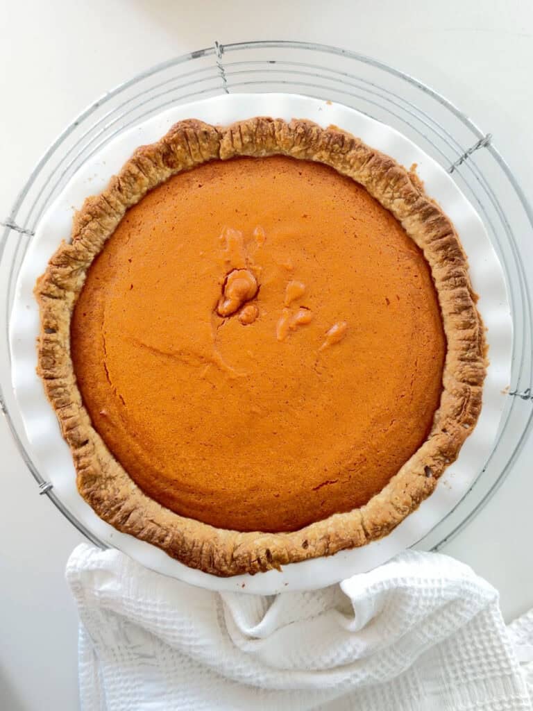 Baked old-fashioned sweet potato pie in a white dish on a wire rack.